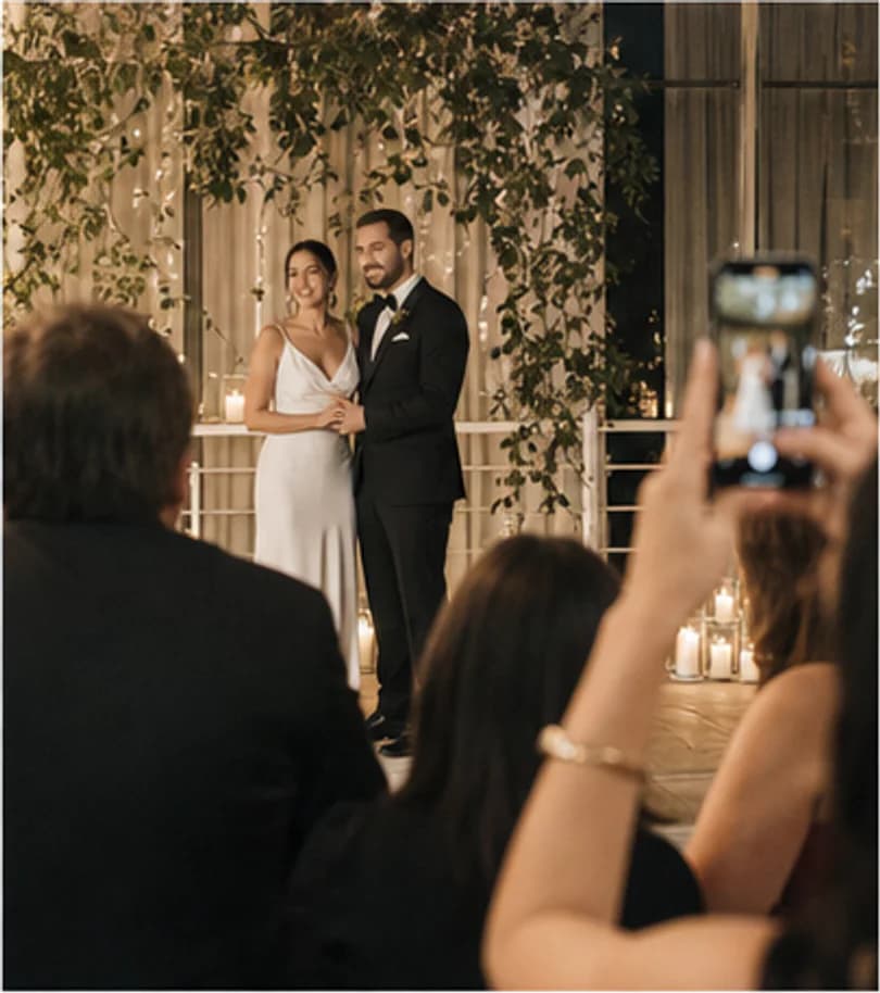 A candid view of the couple photographed by a wedding guest